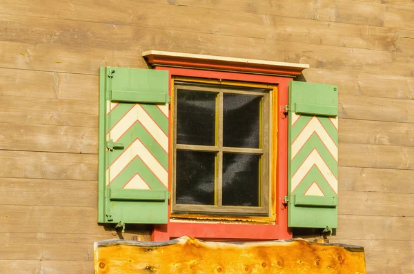 Alpine houten gevel met oranje venster — Stockfoto