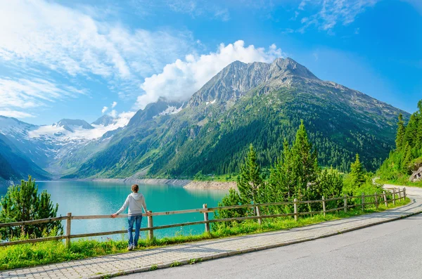 Młoda kobieta stoi nad górskim jeziorem, Austria — Zdjęcie stockowe