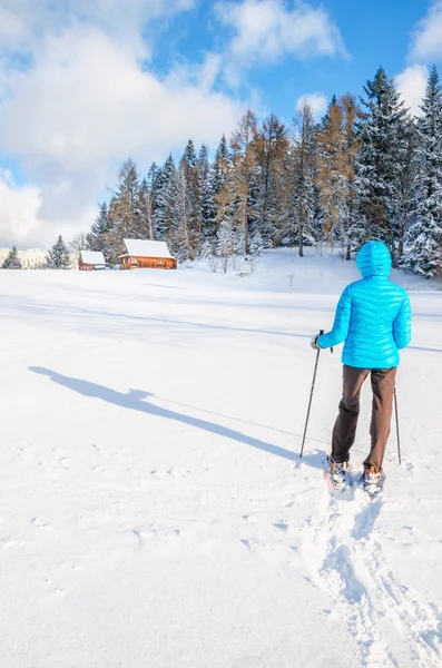Молода жінка ходить зі снігоходами на свіжому снігу — стокове фото