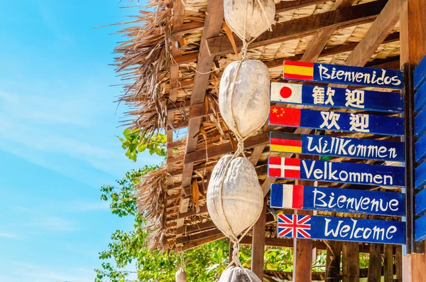 Welcome sign in different languages on beach — Stock Photo, Image