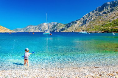 Oynayan küçük çocukla Yunan Adası üzerinde defne deniz