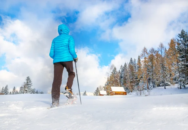 Mujer joven corriendo con raquetas de nieve en invierno — Foto de Stock