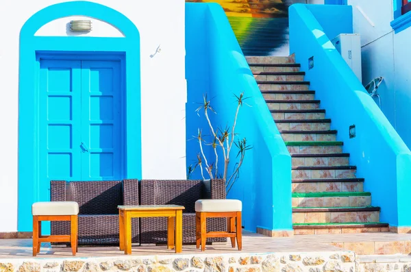 Sofa in front of Greek house painted with blue — Stock Photo, Image