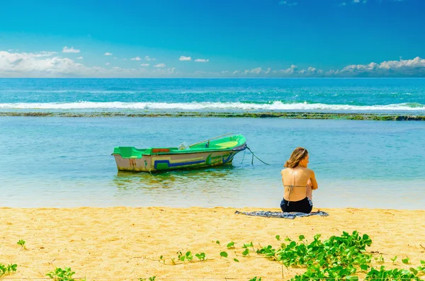 Exotic beach, young girl, fishing boat and water — Stock Photo, Image