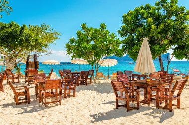 Wooden tables with sun umbrellas at luxury resort clipart