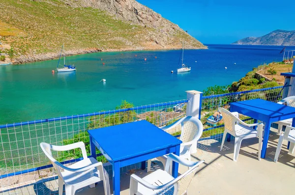 Blue wooden tables and chairs in bay, Greek Island — Stock Photo, Image