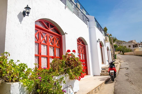Moto rojo frente a la típica casa griega — Foto de Stock