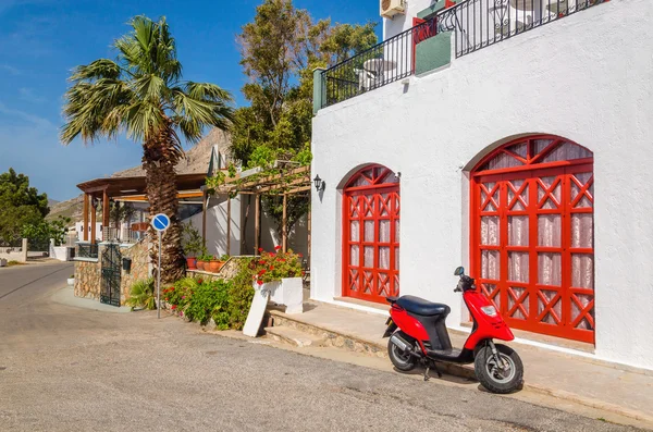 Red motorbike in front of typical Greek house — Stock Photo, Image
