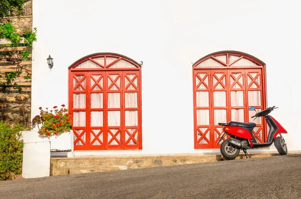 Moto rossa di fronte alla tipica casa greca — Foto Stock