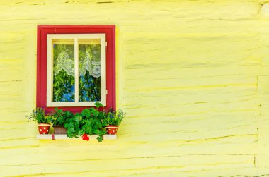 Wooden yellow hut and window with flowers