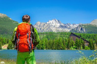 man with  backpack  on mountain lake