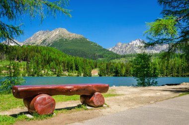 Bench, mountain lake and peaks