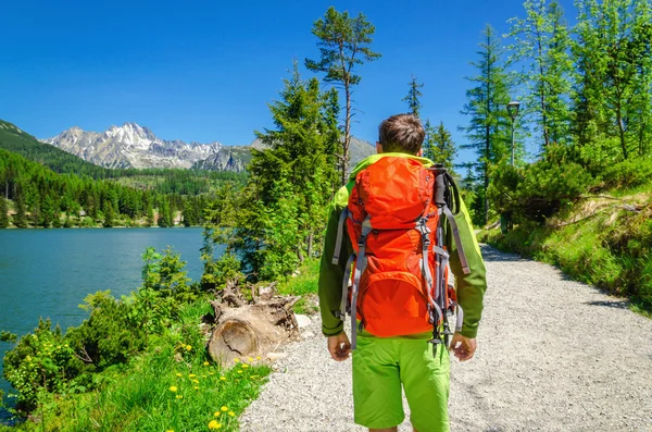 Man trekking along mountain lake — Stockfoto