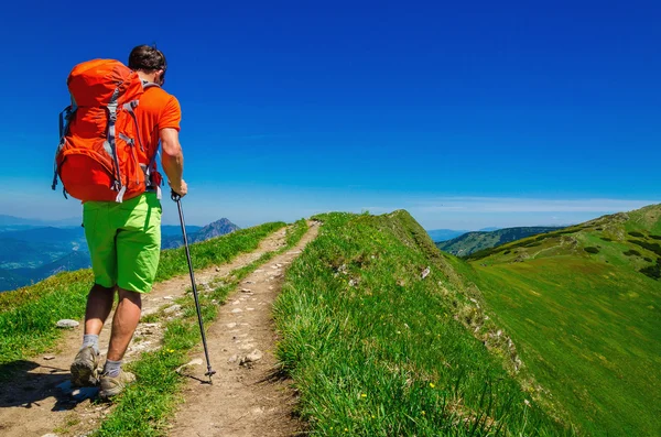 Homem com mochila andando nas montanhas — Fotografia de Stock