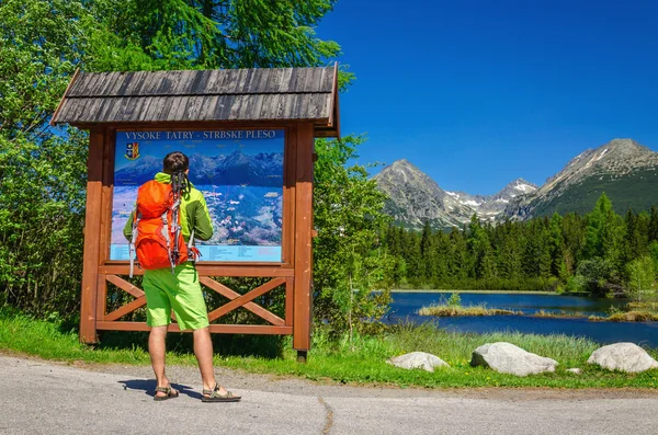 Man watching map of mountain trails — Stock Photo, Image