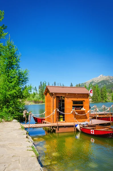 Mountain lake Strbske pleso and red boats — Stok fotoğraf