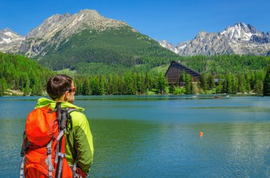 tourist with backpack at mountain lake