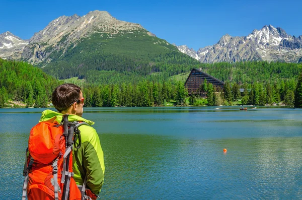 Tourist with backpack at mountain lake — Stock fotografie