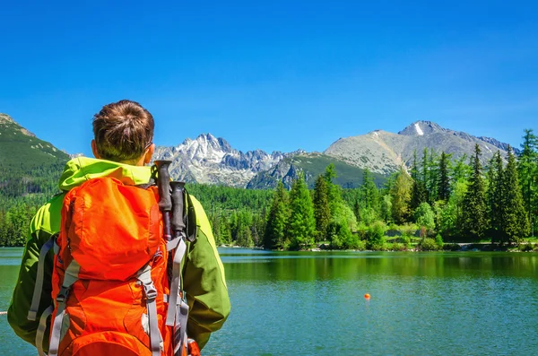 Ung man beundrar mountain lake Štrbské Pleso — Stockfoto