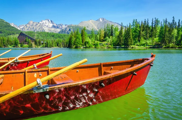 Red wooden boats on mountain lake Strbske Pleso — Stock Photo, Image