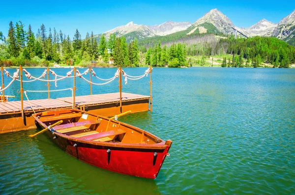 Vörös fából készült csónakok a hegyi tó, Szlovákia, Európa — Stock Fotó
