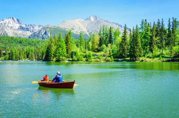 Baba çocuk dağ gölü teknede kürek ile — Stok fotoğraf