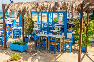 Blue wooden tables and chairs in Greek restaurant