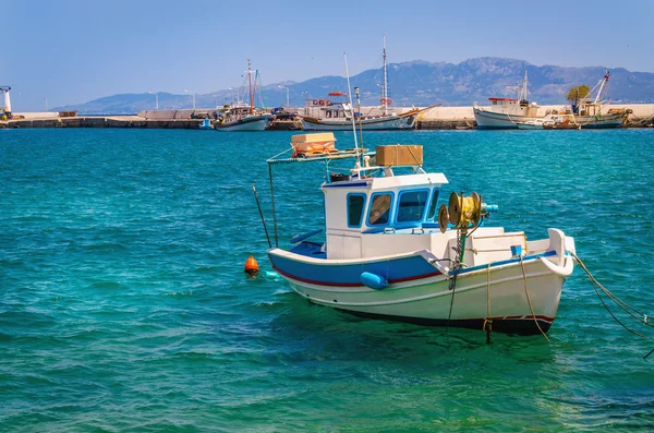 Barca blu-bianca galleggiante su acque limpide, Grecia — Foto Stock