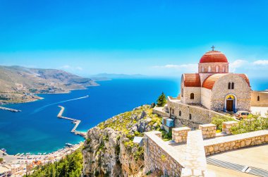 Cliff, Yunanistan üzerinde kırmızı çatı ile uzak kilise