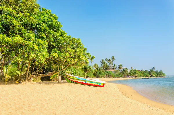 Wilder und exotischer asiatischer Strand mit buntem Boot — Stockfoto