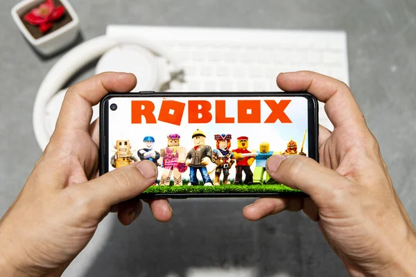 LONDON, UK - March 2021: Person holding a smartphone with Roblox game logo  Stock Photo