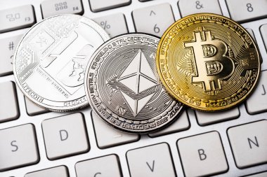 Üç madeni para - Litcoin, Ethereum ve Bitcoin klavyede. Kripto para birimi kavramları.