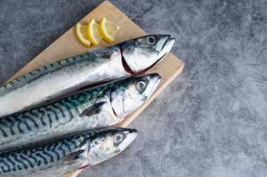 Ahşap zemin üzerinde mermer zemin üzerinde uskumru. Uzayı kopyala Taze balık kavramı.