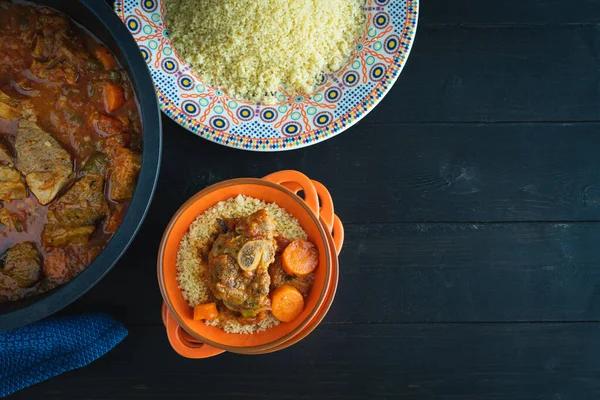 Lamb with couscous on black wooden background. Copy space. Ramadan and Arabic food. Top view.