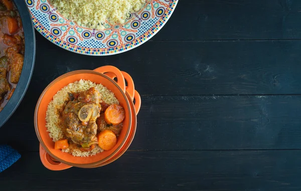 Lamb with couscous on black wooden background. Copy space. Ramadan and Arabic food. Top view.