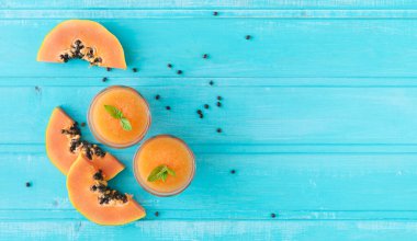 Papaya dilimleri. Ahşap kalasların mavi arka planı. Uzayı kopyala Üst görünüm.