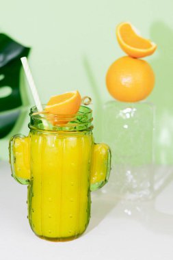 Kaktüs şeklinde cam, portakal suyu ve buz kalıbında meyve süslemesi. Boşluğu kopyala.