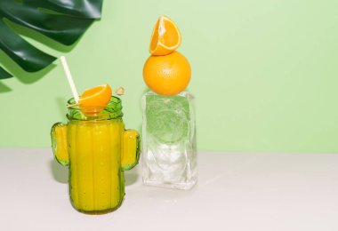 Kaktüs şeklinde cam, portakal suyu ve buz kalıbında meyve süslemesi. Boşluğu kopyala.