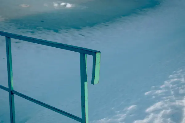 Karlı bir gölün arka planında mavi korkuluklar