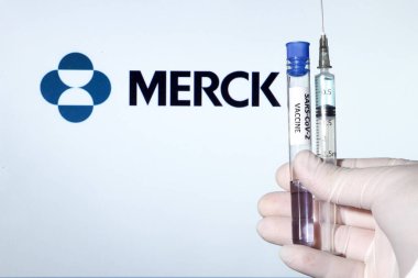 Madrid, İspanya... 7 Ocak 2020 'de elinde Covid aşısı olan beyaz ameliyat eldiveni vardı. Beyaz arkaplanda Merck Laboratuvarı logosu.