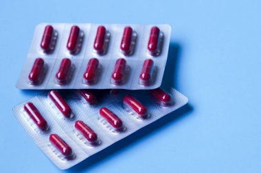 Kırmızı kapsüller mavi arkaplanda su topladı