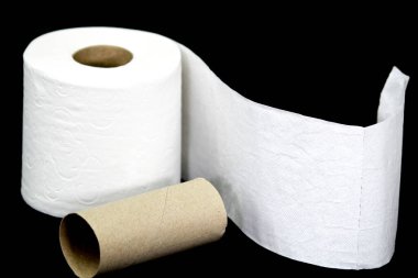 Siyah arka planda beyaz tuvalet kağıdı boş olanın yanında yuvarlanıyor.