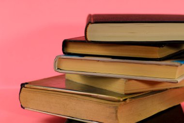 Pembe arkaplandaki Yığılmış Kitaplar