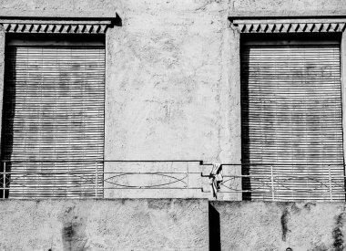 İspanya 'da kör ve paslı balkonu olan eski bir ev cephesi. Tek renkli resim.