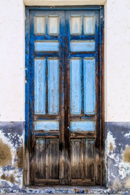 Torrellano köyü, Elche, Alicante, İspanya 'da küçük bir evin mavi ahşap pencereleri ve kapısı olan eski renkli ve görkemli beyaz cephe. 