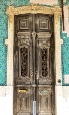 Lizbon 'da fayanslarla döşenmiş eski ahşap kapı. Kapıya metal yazmışlar..