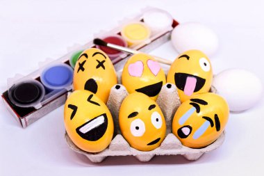 Alicante, İspanya - 18 Mart 2021 Emoticons Yumurta kabında Paskalya Yumurtaları, boya ve beyaz arka planda fırça
