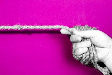 Mor arka plandaki kadın özgürlüğü eksikliğini simgeleyen iple bağlanmış bir el.