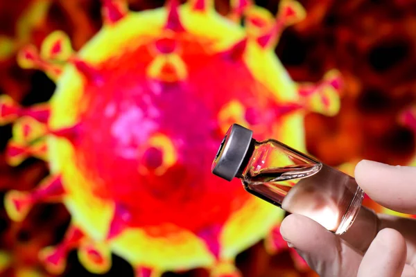 Medical professional hand with surgery glove holding vial filled with Covid-19 virus vaccine and covid virus microscopic image in the background