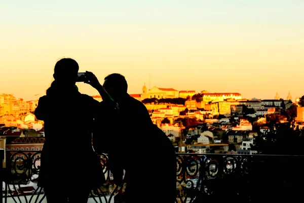 People watching the sunset in a viewpoint of Lisbon in Autumn